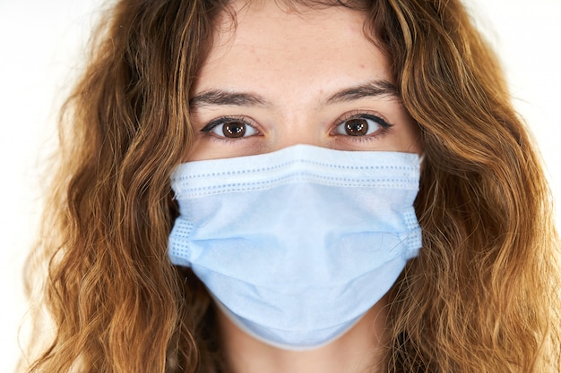 Retrato de estudio de joven mujer que llevaba una mascarilla médica