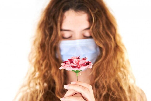 Retrato de estudio de joven mujer que llevaba una mascarilla médica