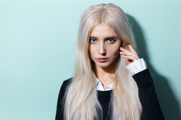 Retrato de estudio de joven rubia con ojos azules en color aqua menthe.