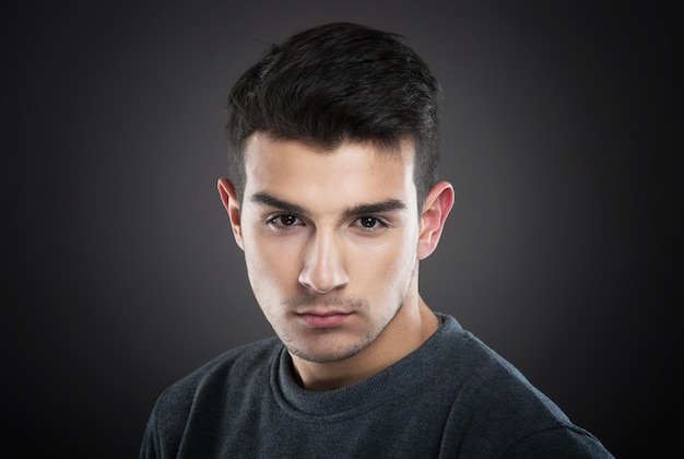 Retrato de estudio de un joven sonriente mirando a la cámara