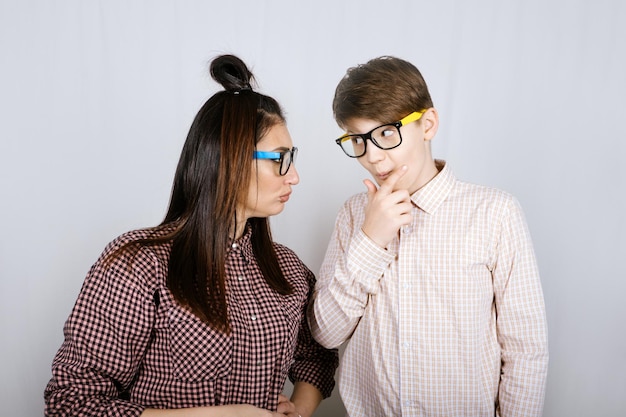 Retrato de estudio de madre de familia feliz y hijo adolescente con gafas de colores divirtiéndose