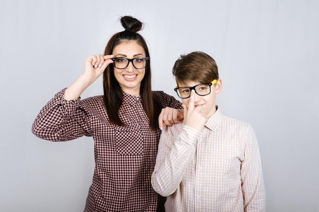 Foto retrato de estudio de madre de familia feliz y hijo adolescente con gafas de colores divirtiéndose
