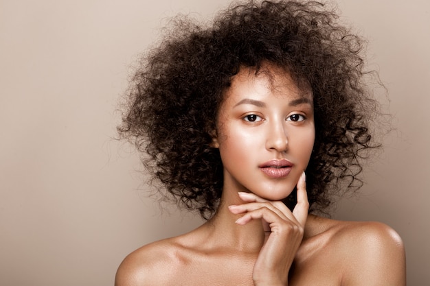 Retrato de estudio de moda de hermosa mujer afroamericana con piel mulata brillante suave perfecta, maquillaje