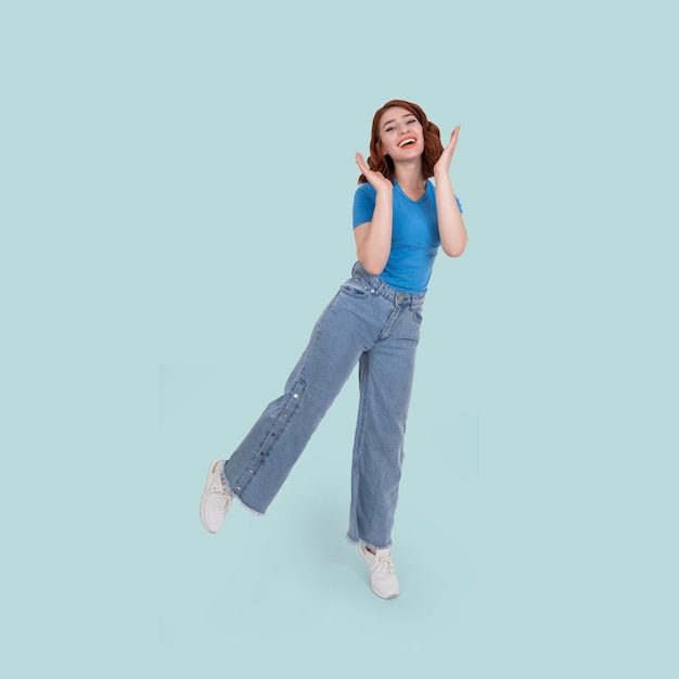 Retrato de estudio de una mujer joven y feliz de cuerpo completo de pie en una pierna bailando