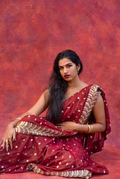 Foto retrato de estudio de mujer joven vistiendo una prenda tradicional sari