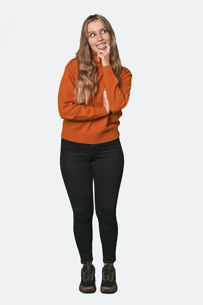 Retrato de estudio de una mujer rubia caucásica relajada pensando en algo mirando un espacio de copia