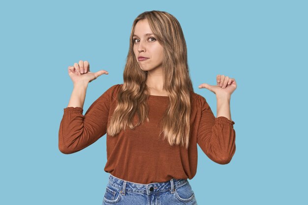 Foto retrato de estudio de una mujer rubia caucásica se siente orgullosa y segura de sí misma ejemplo a seguir