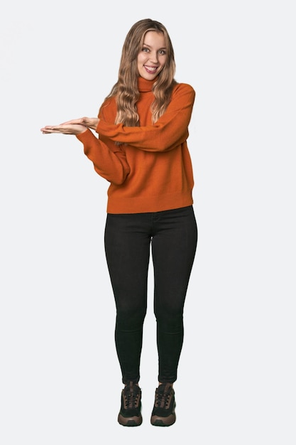 Retrato de estudio de una mujer rubia caucásica sosteniendo un espacio de copia en una palma