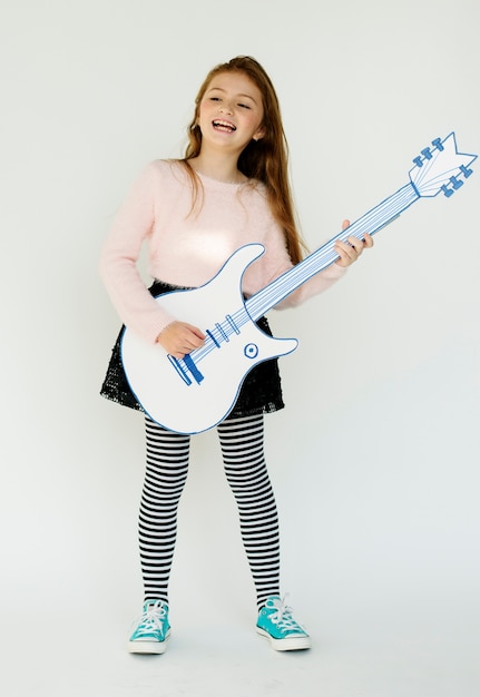 Retrato de estudio de música de guitarra de papercraft de niña pequeña sosteniendo