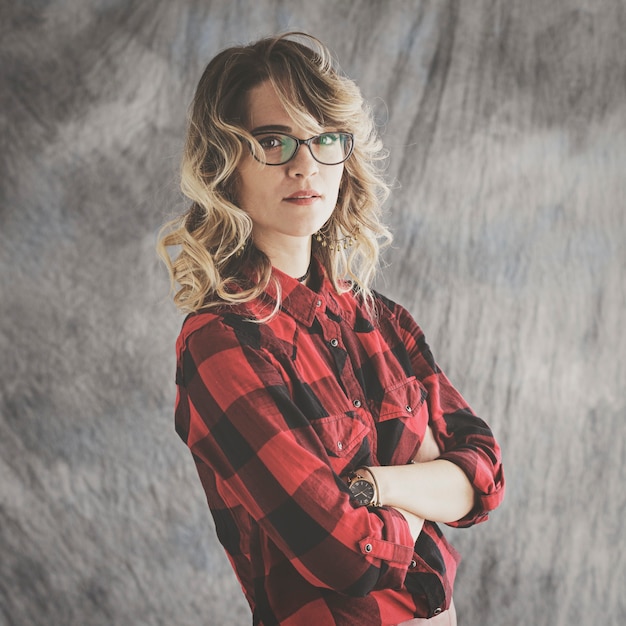 Retrato de estudio de niña con gafas sobre fondo gris