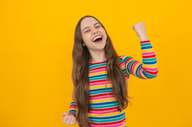 Retrato de estudio de un niño adolescente haciendo un gesto de ganador