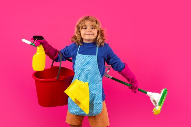 Retrato de estudio de un niño que ayuda con las tareas domésticas limpiando la casa