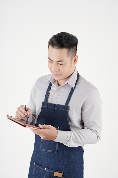 Retrato de estudio del propietario de una cafetería con tableta al pedir suministros de café y leche ...