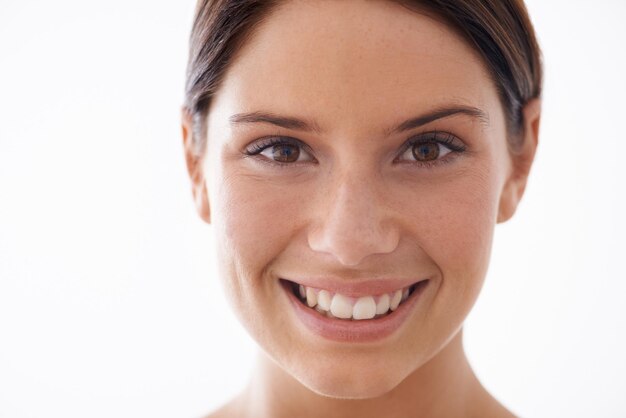 Foto retrato de estudio de sonrisa de belleza y mujer con resultados de cuidado de la piel tratamiento matutino y brillo facial cosmetología rostro feliz y modelo con cuidado antienvejecimiento y rutina de salón de spa en fondo blanco