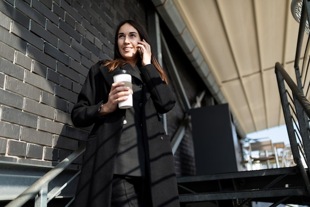 Retrato de una exitosa mujer independiente moderna vestida de negocios hablando por un teléfono móvil en un