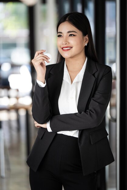 Retrato de una exitosa mujer de negocios en traje de pie en la oficina
