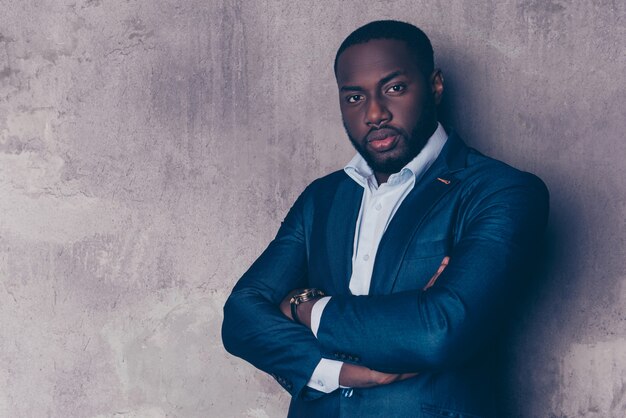 Retrato de exitoso hombre afroamericano guapo en elegante traje cruzó las manos