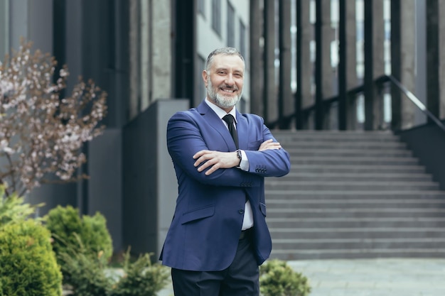 Retrato de un exitoso hombre de negocios senior en un traje de negocios y corbata de pie con confianza