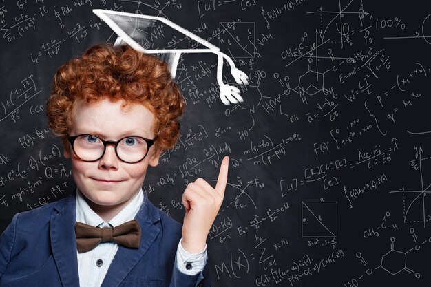 El retrato exitoso del niño estudiante en el sombrero de graduación Cómo pasar los exámenes