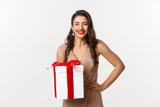 retrato expressivo jovem em um vestido elegante segurando uma caixa de presente