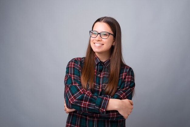 Retrato f jovem com os braços cruzados, olhando para longe sobre parede branca