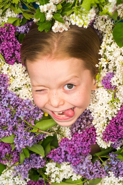 Retrato facial engraçado de uma linda garotinha piscando Adolescente piscando Menina adolescente com buquê de p