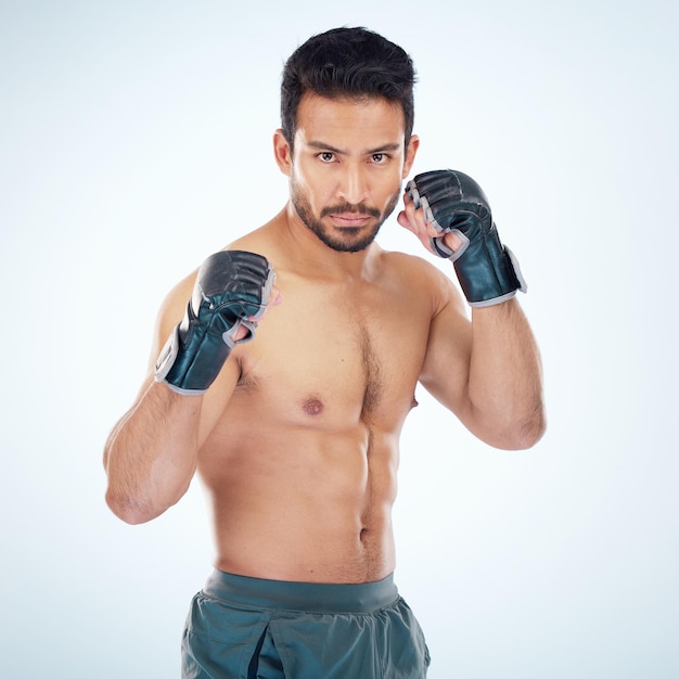 Retrato facial mma sports y hombre en estudio sobre fondo azul Fitness corporal de artes marciales y luchador o boxeador masculino serio listo para entrenamiento o ejercicio para combate o competencia