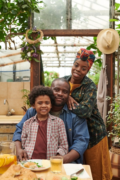 Retrato de familia africana con un niño sonriendo a la cámara durante la cena en casa