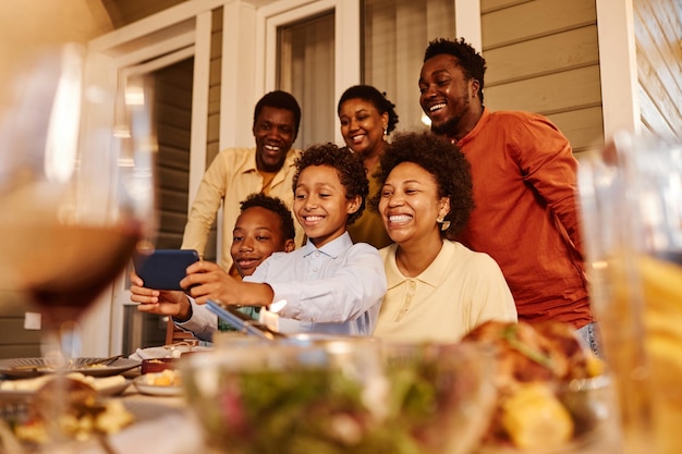 Retrato de una familia afroamericana feliz tomando una foto selfie en la terraza de la casa por la noche