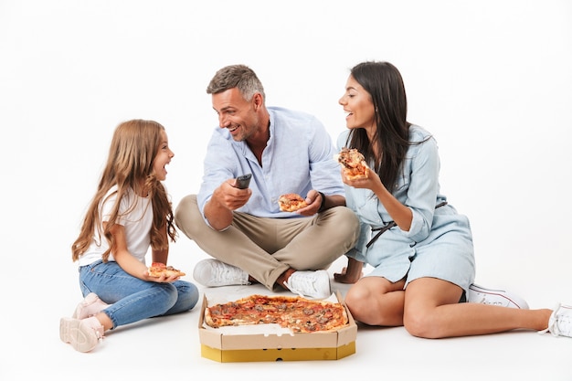 Foto retrato de una familia alegre comiendo pizza