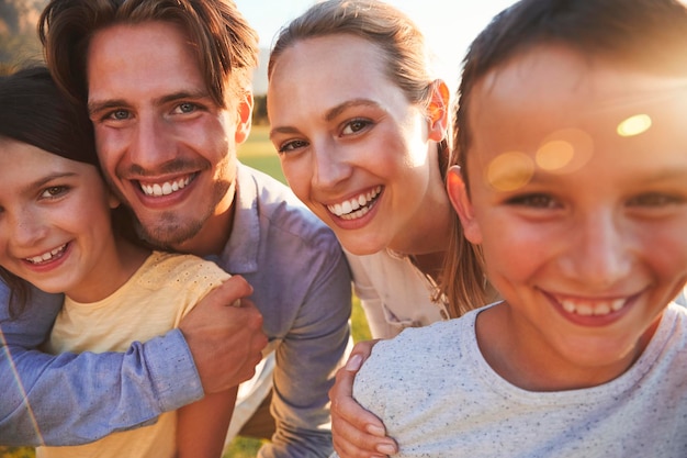 Foto retrato de familia blanca feliz abrazando al aire libre de cerca