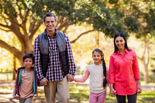 Retrato de familia cogidos de la mano en el parque