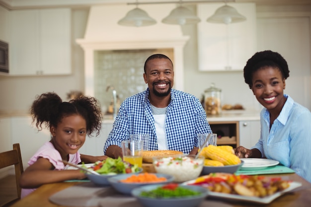 Retrato de familia comiendo en la mesa de comedor en casa