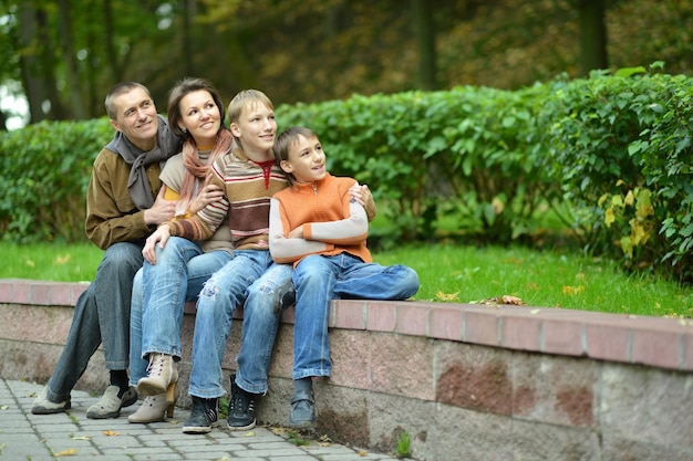 retrato, de, familia de cuatro, sentado, en el parque