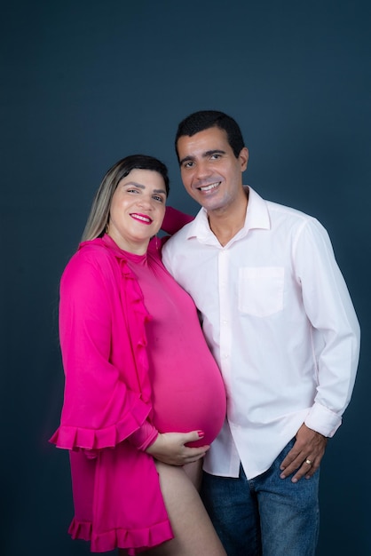 Foto retrato de una familia esperando a su bebé retrato de estudio aislado sobre fondo azul oscuro