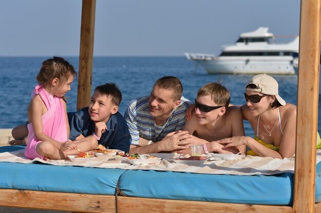 Retrato de una familia feliz almorzando en la playa