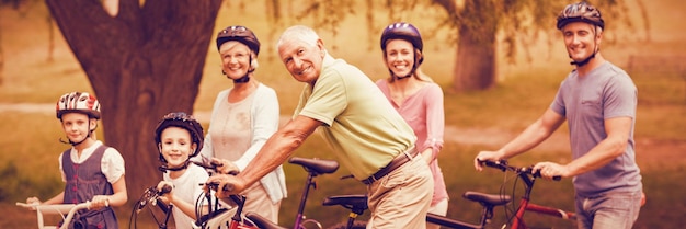 Retrato de familia feliz en bicicleta en el parque