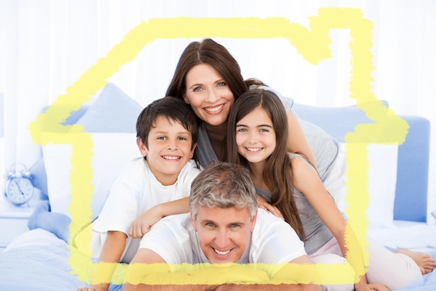 Retrato de familia feliz en la cama contra el contorno de la casa