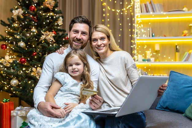 Retrato familia feliz en casa para festividad y año nuevo sonriendo y mirando a la cámara tres personas