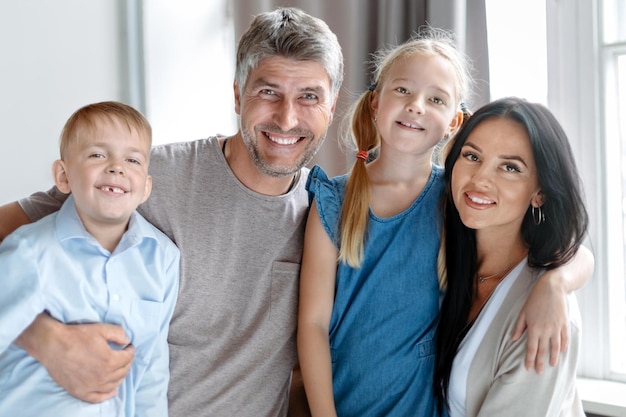 Retrato de una familia feliz cerca de la ventana