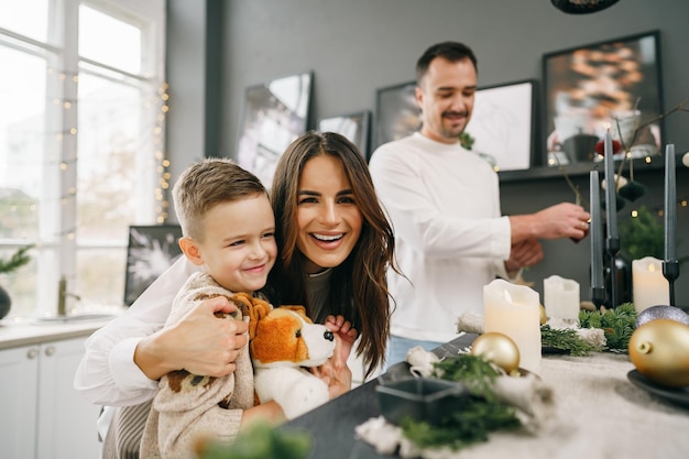 Un retrato de familia feliz en la cocina decorada para las vacaciones de Navidad