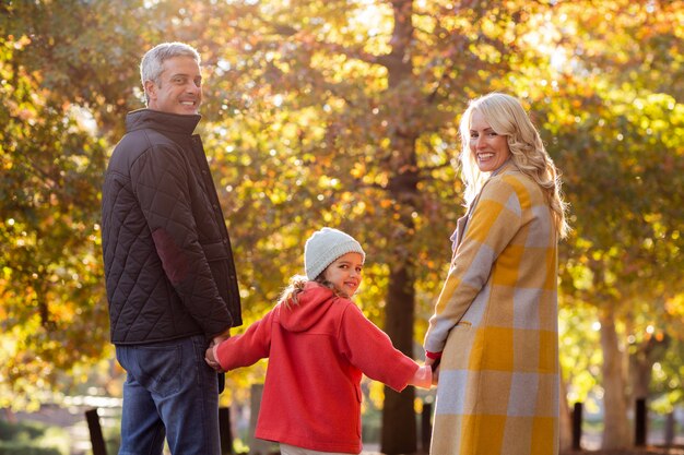 Retrato de familia feliz contra árboles