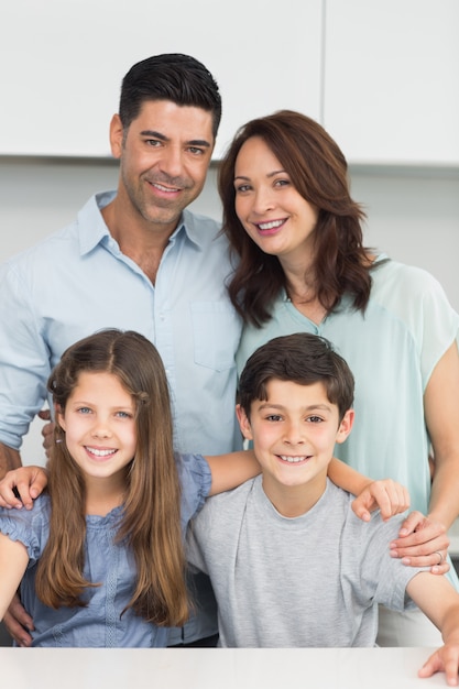 Retrato de una familia feliz de cuatro en la cocina