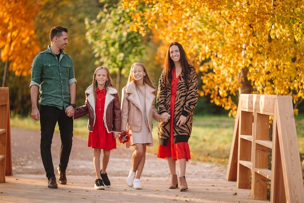 Retrato de familia feliz de cuatro en día de otoño