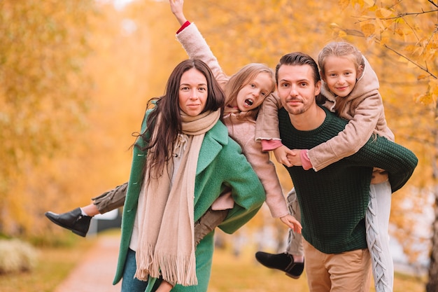 Retrato de familia feliz de cuatro en día de otoño