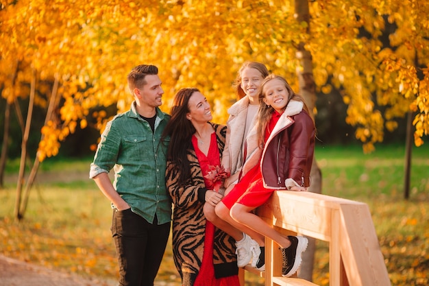 Retrato de familia feliz de cuatro en día de otoño