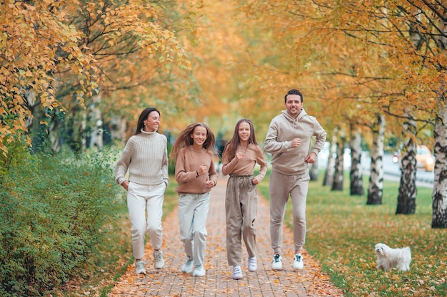 Retrato de familia feliz de cuatro en día de otoño