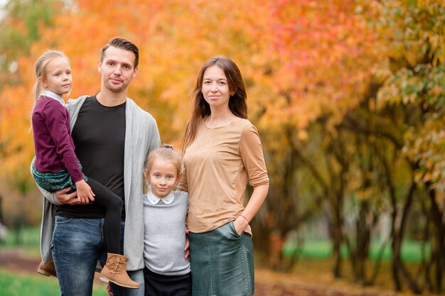 Retrato de familia feliz de cuatro en día de otoño