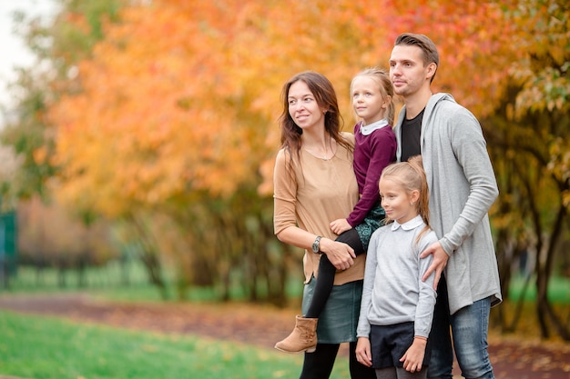 Retrato de familia feliz de cuatro en día de otoño