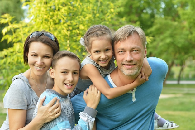 Retrato de una familia feliz descansando en el parque de verano